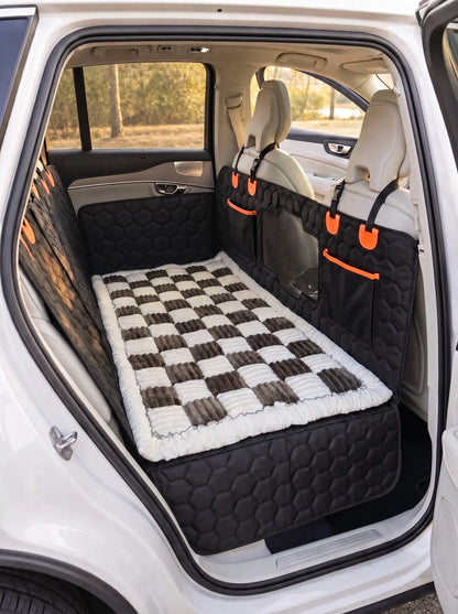 A pet car bed with a black and white checkered pattern and a white faux fur trim, shown installed in the back of a white SUV. The bed is fitted between the rear seats on top of the silverhammock car seat cover